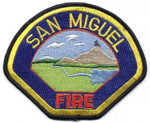 San Miguel - Distintivo blu con al centro un paesaggio
