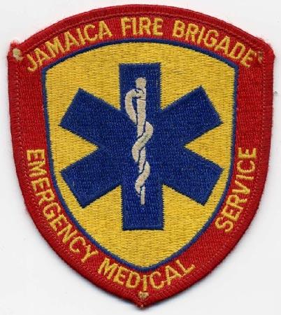 Jamaica - Distintivo rosso con al centro la croce medica blu su sfondo giallo