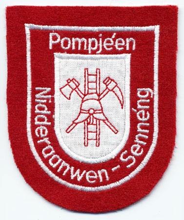 Nidderaanwen-Senneng - Distintivo rosso con al centro un elmo e una scala su sfondo bianco