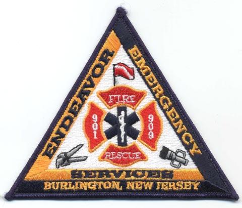 Burlington - Distintivo triangolare nero con al centro al croce blu medica su sfondo bianco