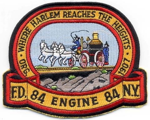 New York - Distintivo giallo e rosso con al centro un mezzo antincendio trainato da cavalli