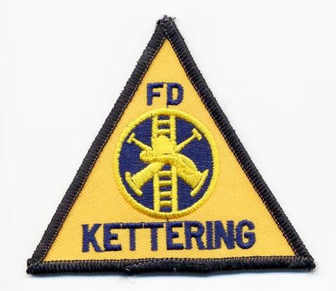 Kettering - Distintivo triangolare giallo con al centro un elmo su sfondo nero