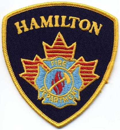 Hamilton - Distintivo blu con al centro una fiamma su sfondo azzurro
