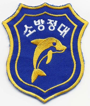 South Korea - Distintivo blu con al centro un delfino giallo