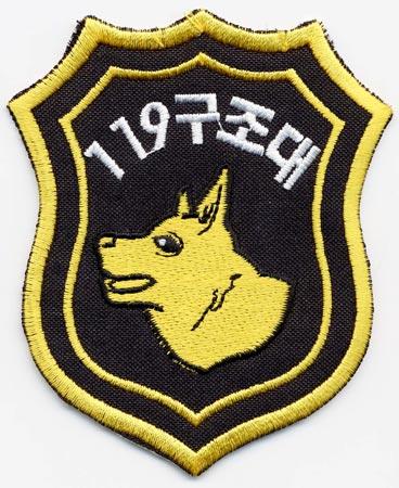 South Korea - Distintivo nero con al centro un cane giallo