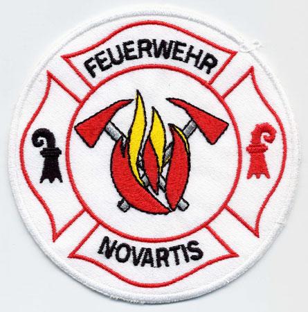 Basel (Novartis) - Distintivo bianco con al centro fiamme e il logo Novartis