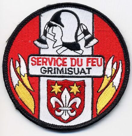 Grimisuat - Distintivo rosso con al centro un elmo su sfondo di fiamme