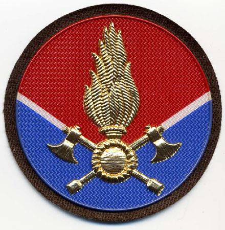 Capo Reparto Volontario (Da Cappello) - Distintivo rotondo rosso e blu con al centro fiamma dorata e V bianca
