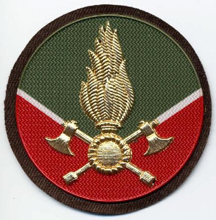 Vigile Volontario (Da Cappello) - Distintivo rotondo verde e rosso con al centro fiamma dorata e V bianca